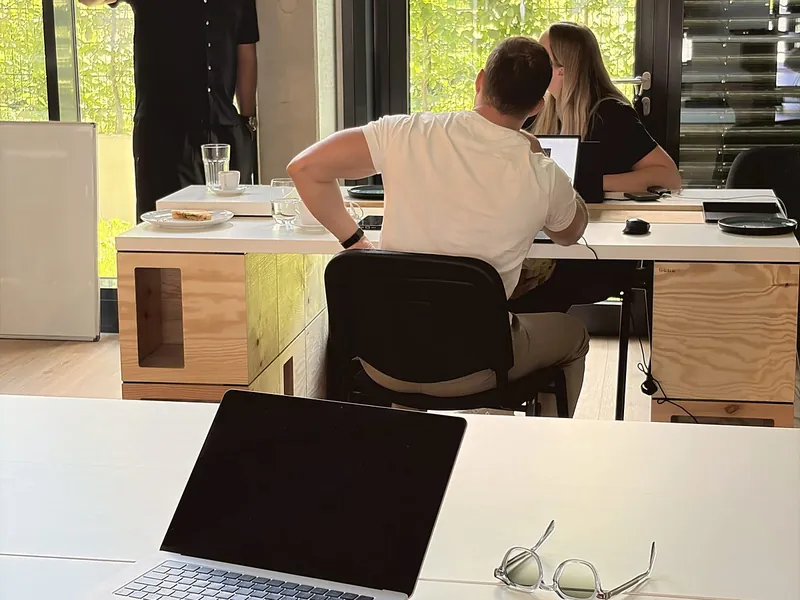 Blick durch den Raum, vorne ein Bauplatz mit Laptop